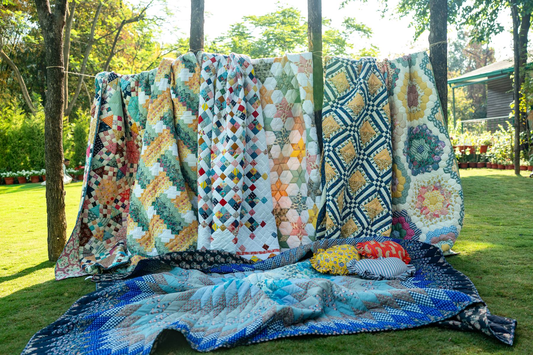 Handstitched Purkal quilts drying on a garden clothesline, Dehradun