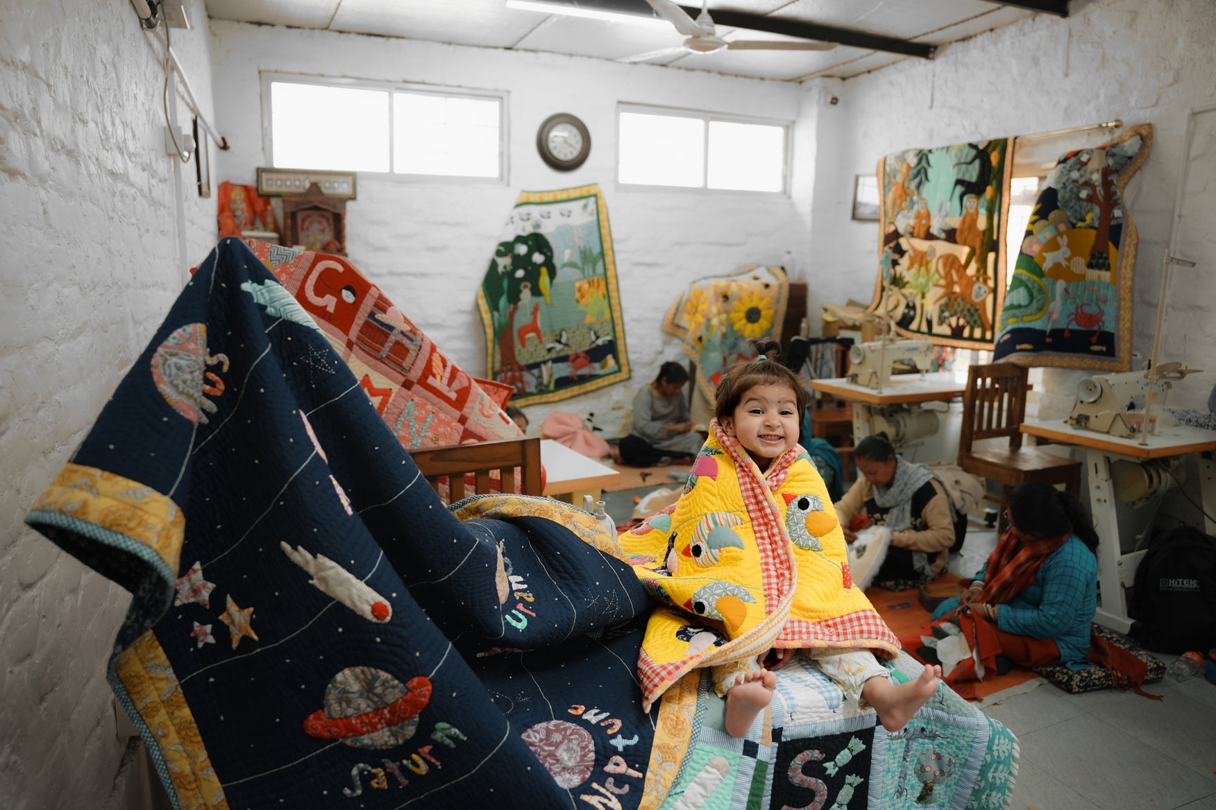 Mother and daughter wrapped in heart appliqué quilts